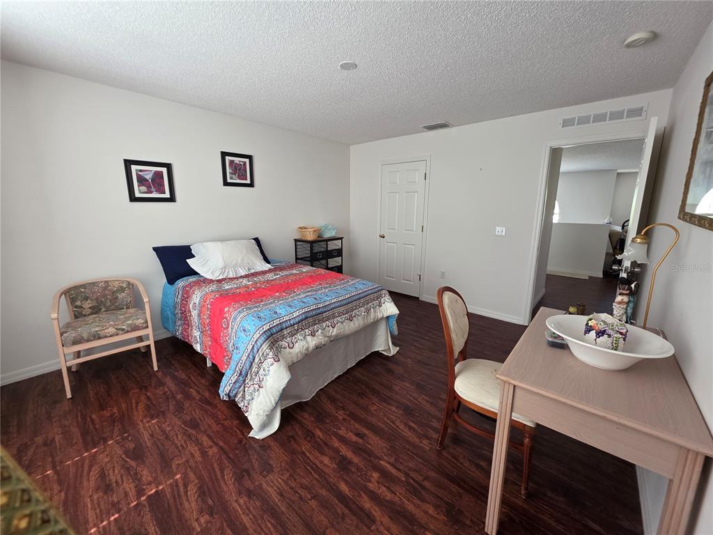 9276 Elm Court Spring Hill, FL 34606 - Photo 19 of 35 a bedroom with a bed and a table