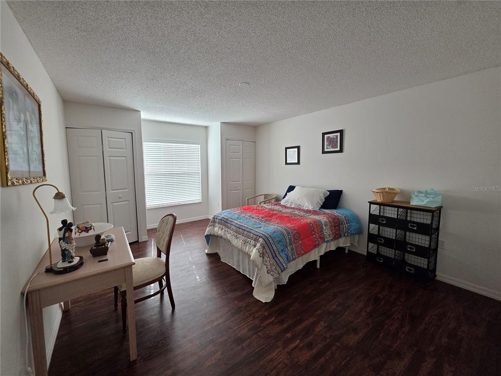 9276 Elm Court Spring Hill, FL 34606 - Photo 20 of 35 a bedroom with a bed a dresser with wooden floor
