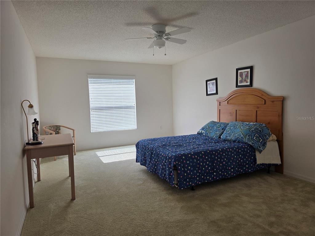 9276 Elm Court Spring Hill, FL 34606 - Photo 22 of 35 a living room with a bed furniture and paintings on the wall