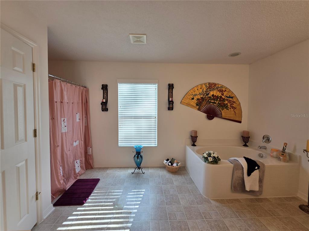 9276 Elm Court Spring Hill, FL 34606 - Photo 30 of 35 a view of a bedroom with baby crib and lounge chair