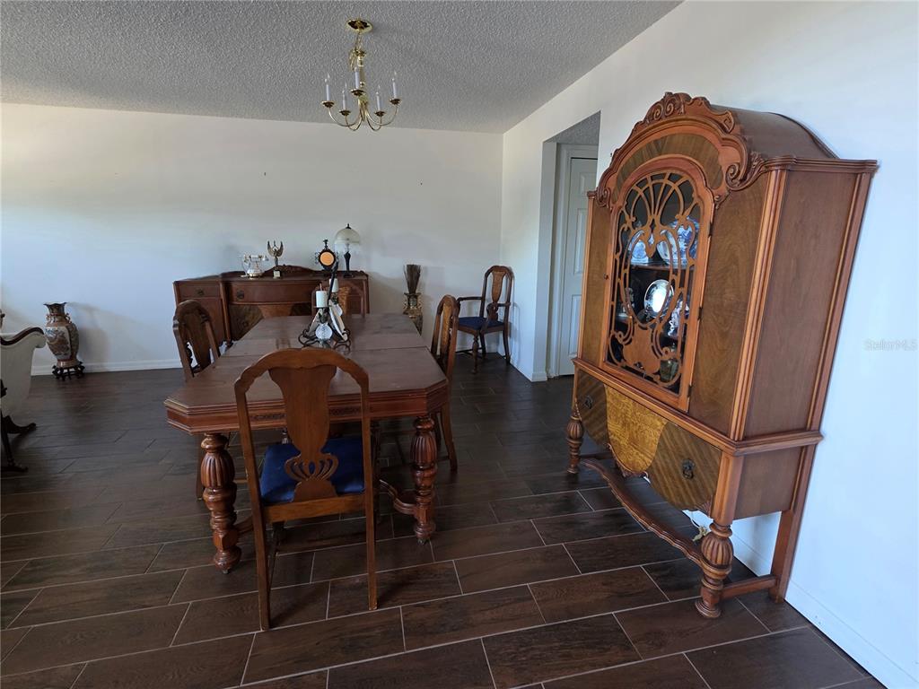 9276 Elm Court Spring Hill, FL 34606 - Photo 3 of 35 a view of a dining room with furniture and wooden floor