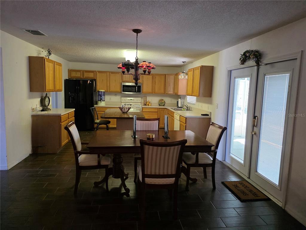 9276 Elm Court Spring Hill, FL 34606 - Photo 4 of 35 a view of a dining room with furniture window and wooden floor