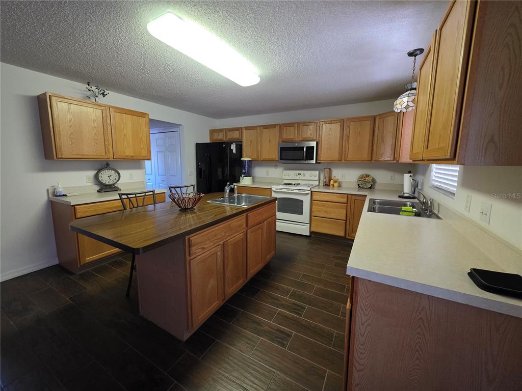 9276 Elm Court Spring Hill, FL 34606 - Photo 5 of 35 a kitchen with a sink a stove and cabinets