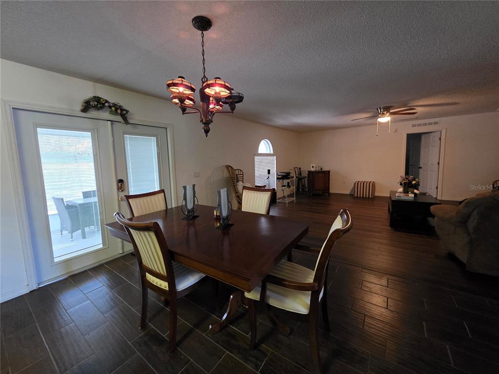 9276 Elm Court Spring Hill, FL 34606 - Photo 7 of 35 a view of a dining room with furniture wooden floor and chandelier