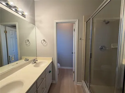 a bathroom with a granite countertop sink shower and a mirror