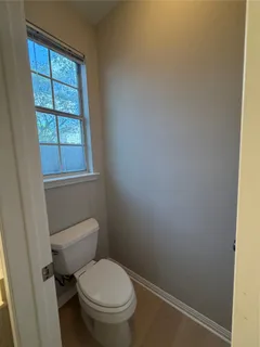 a white toilet sitting next to a window