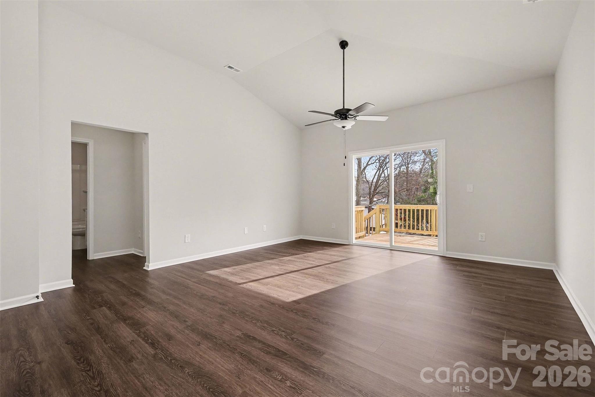 508 Mill Street Lowell, NC 28098 - Photo 17 of 27 a view of an empty room with wooden floor kitchen view and a window