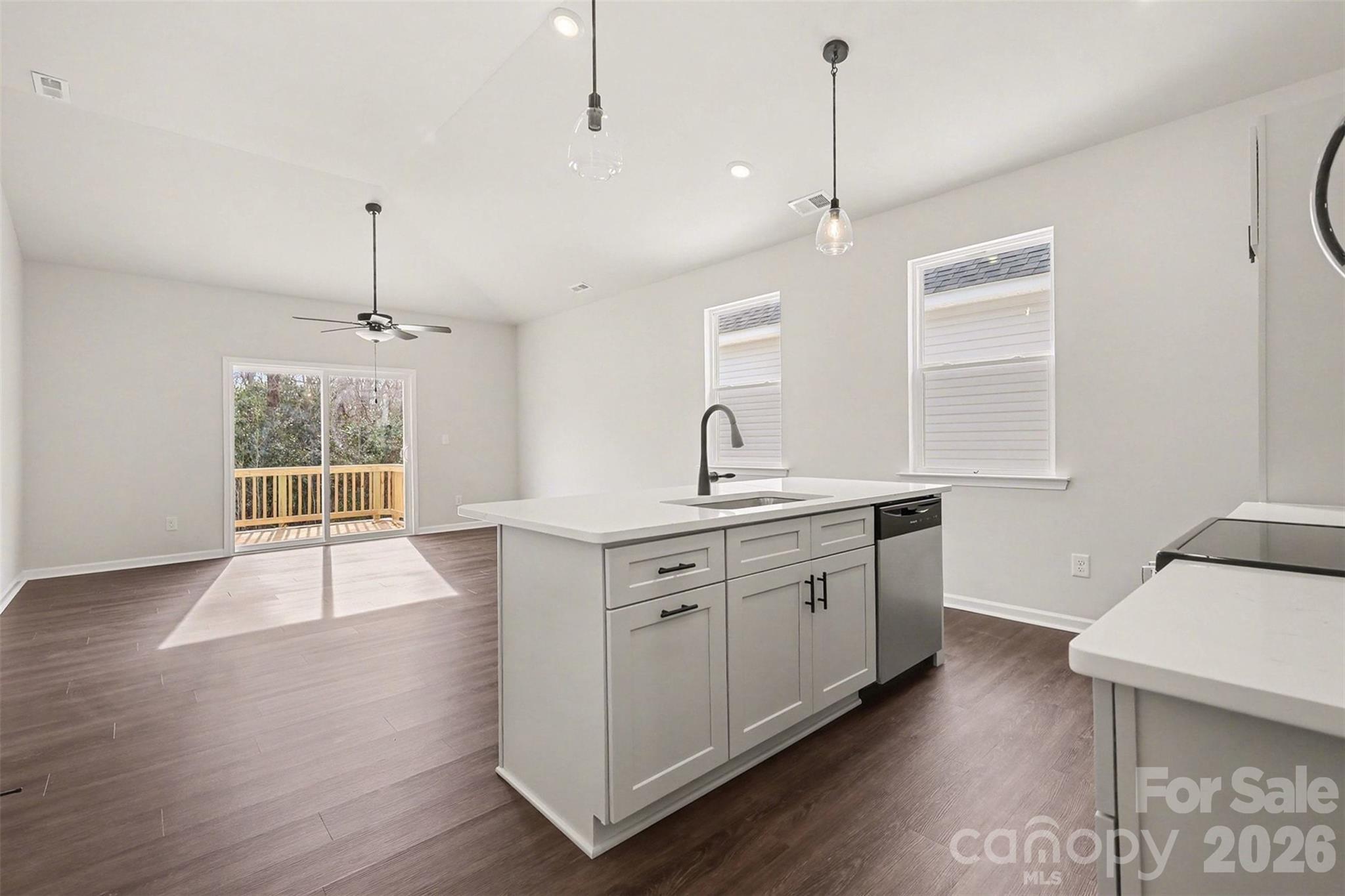 508 Mill Street Lowell, NC 28098 - Photo 7 of 27 a open kitchen with a sink a window and wooden floor