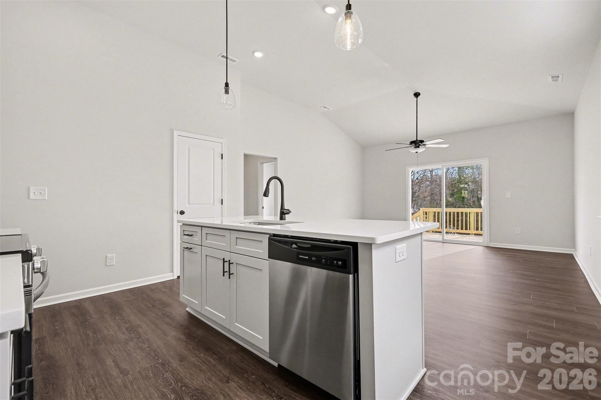 508 Mill Street Lowell, NC 28098 - Photo 8 of 27 a kitchen with granite countertop a stove a sink and a wooden floor