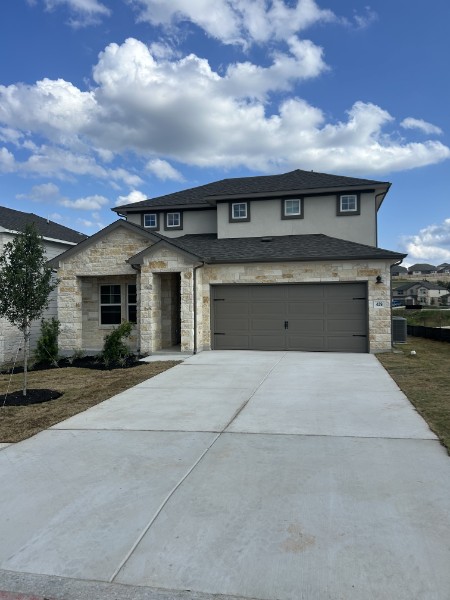 Exterior of house featuring a driveway, garage, and grassy front yard