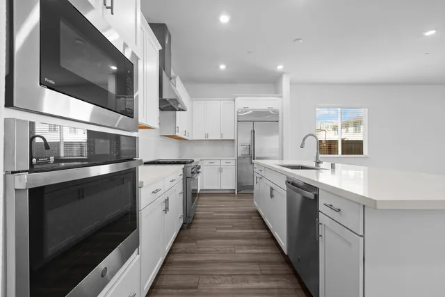a large kitchen with stainless steel appliances kitchen island a stove and a sink