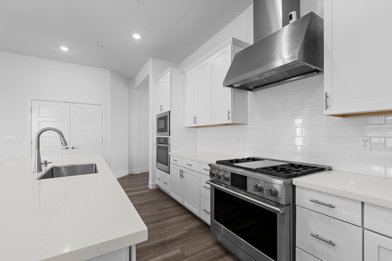 4236 Bellwether Way Sacramento, CA 95835 - Photo 11 of 57 a kitchen with stainless steel appliances a sink dishwasher and a stove with white countertops