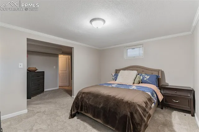 a bed sitting in a bedroom next to a window and a larger closet