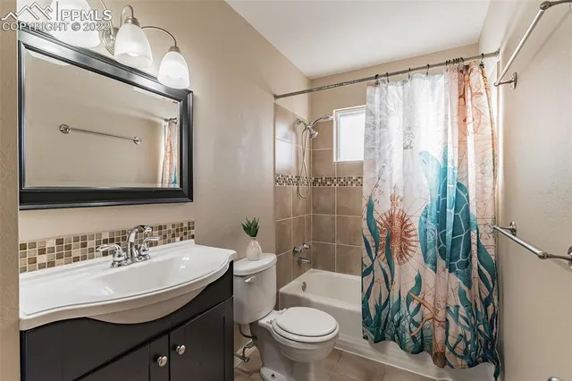 a bathroom with a sink a toilet a mirror and shower