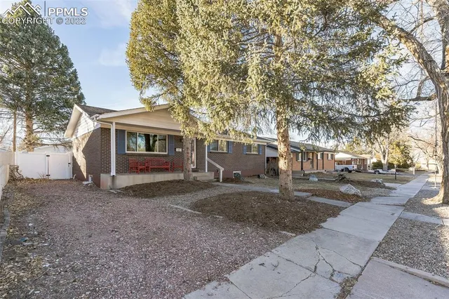 a view of a house with a yard and tree s