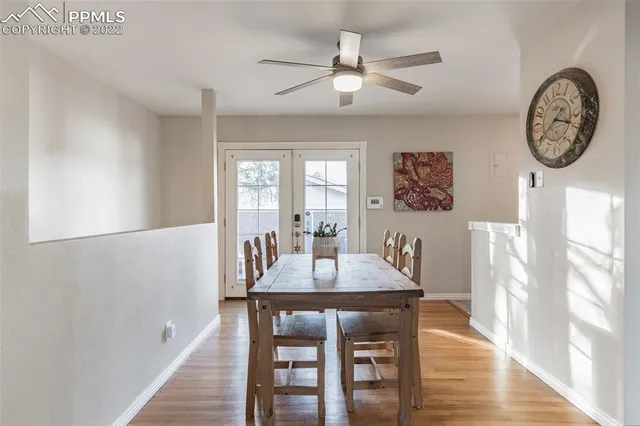 a dining room with wooden floor a chandelier a wooden table and chairs