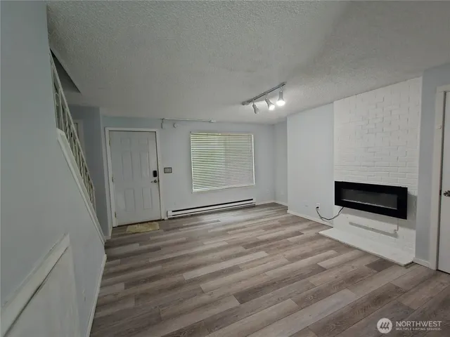 a view of empty room with wooden floor and fireplace