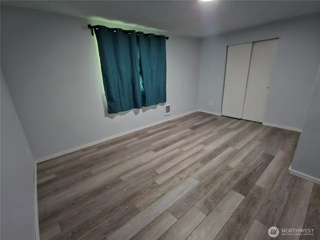 a view of an empty room with wooden floor