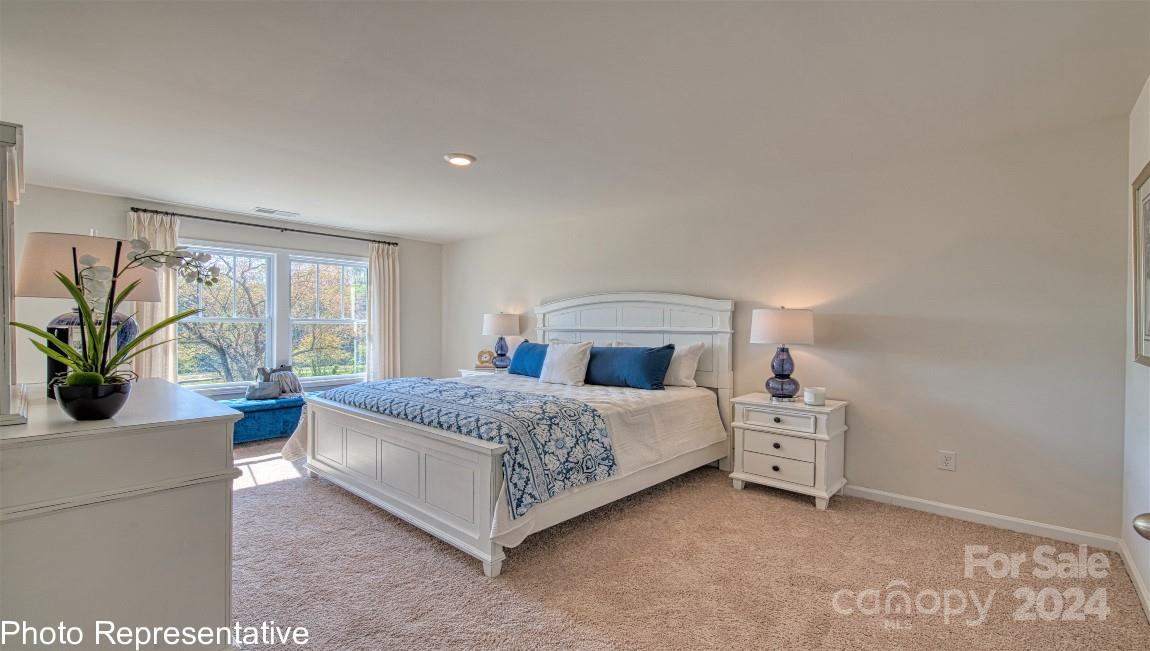 542 Wheatfield Road Fletcher, NC 28732 - Photo 32 of 47 a bedroom with a bed and a potted plant