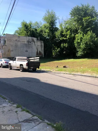 a view of a street with a car parked on the road