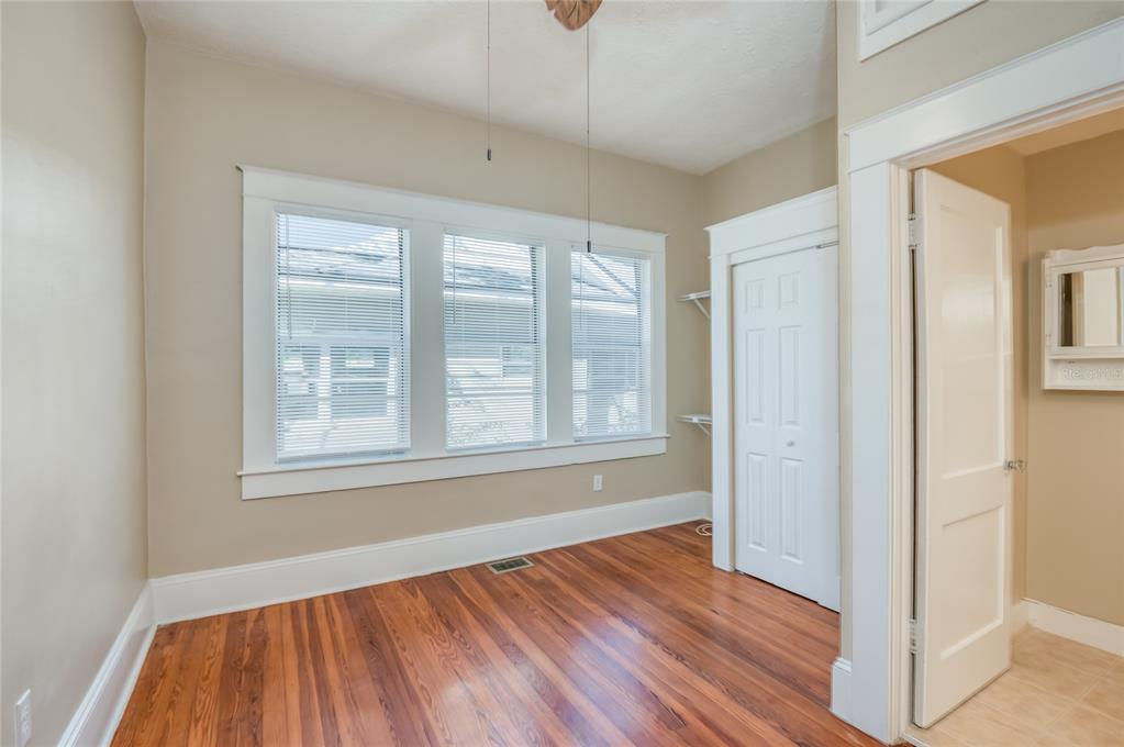 427 East Washington Avenue Eustis, FL 32726 - Photo 22 of 42 an empty room with wooden floor and windows