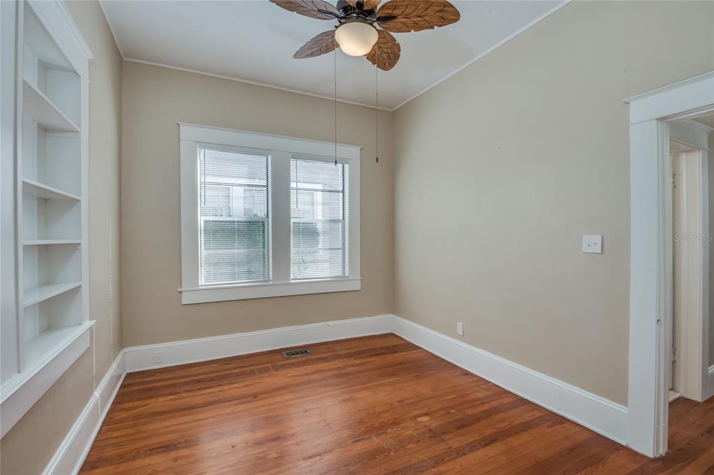427 East Washington Avenue Eustis, FL 32726 - Photo 24 of 42 an empty room with wooden floor chandelier fan and windows