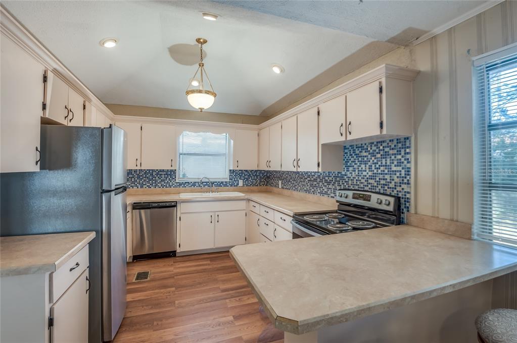 427 East Washington Avenue Eustis, FL 32726 - Photo 27 of 42 a kitchen with granite countertop a stove a sink and a refrigerator