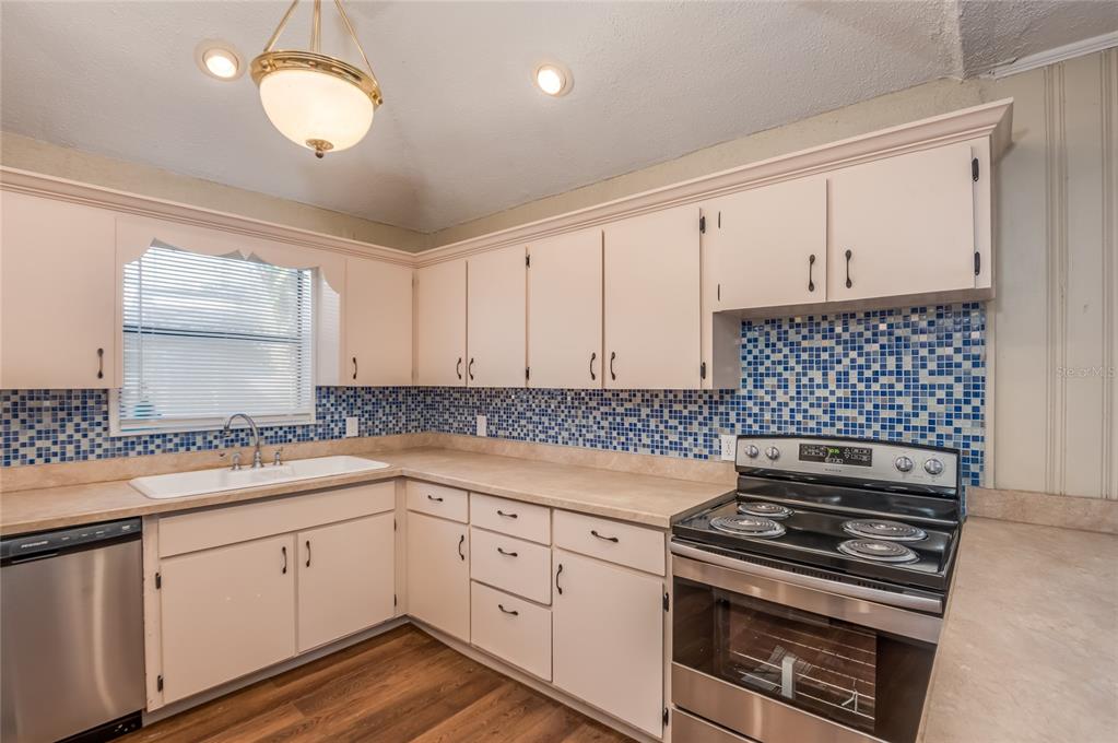 427 East Washington Avenue Eustis, FL 32726 - Photo 30 of 42 a kitchen with white cabinets and appliances