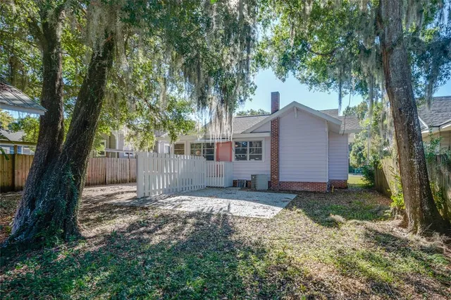 a view of a house with a yard and tree