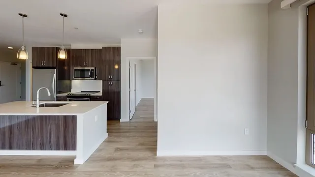 a kitchen with kitchen island a sink stainless steel appliances and cabinets