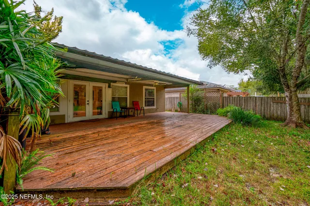 a view of a house with pool and wooden fence