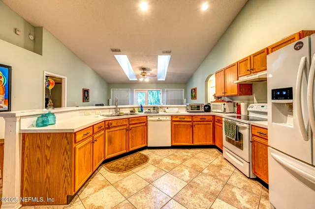 a kitchen with stainless steel appliances granite countertop a sink and white cabinets