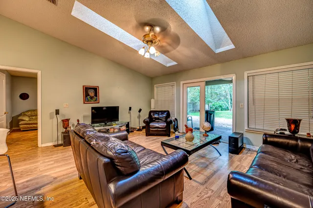 a living room with furniture a flat screen tv and a large window