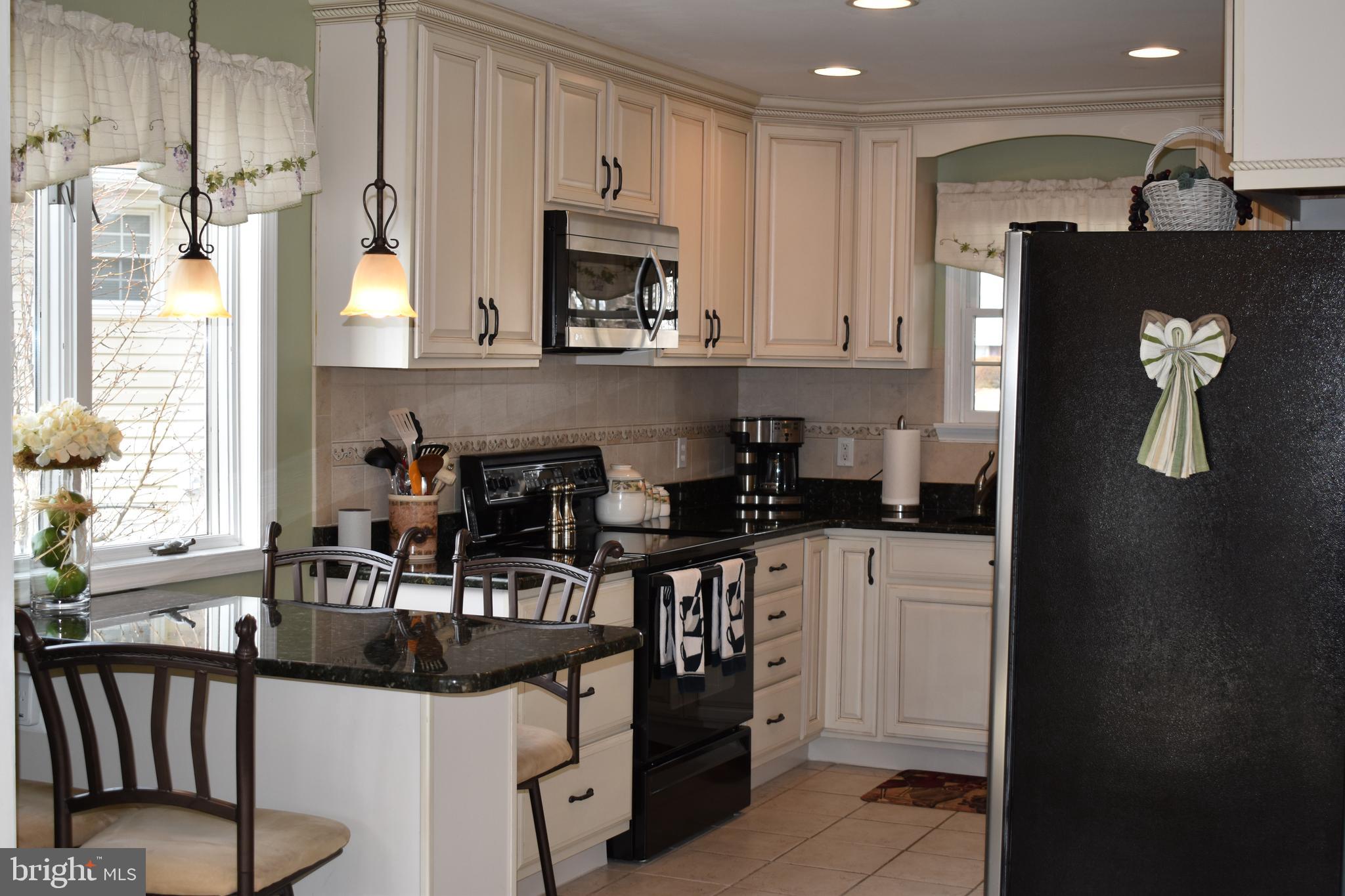 4420 Wynn Road Baltimore, MD 21236 - Photo 3 of 43 a kitchen with stainless steel appliances granite countertop a refrigerator a stove a sink and white cabinets with wooden floor