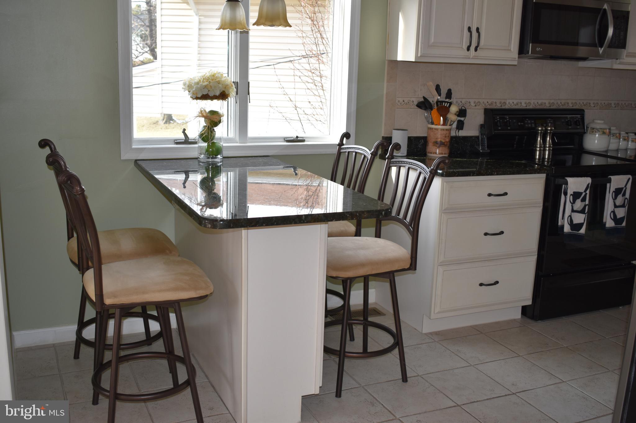 4420 Wynn Road Baltimore, MD 21236 - Photo 5 of 43 a kitchen with stainless steel appliances granite countertop a table chairs in it and a window