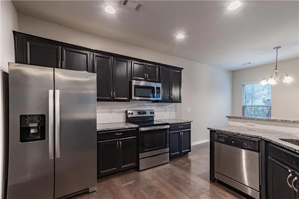 a modern kitchen with stainless steel appliances and refrigerator