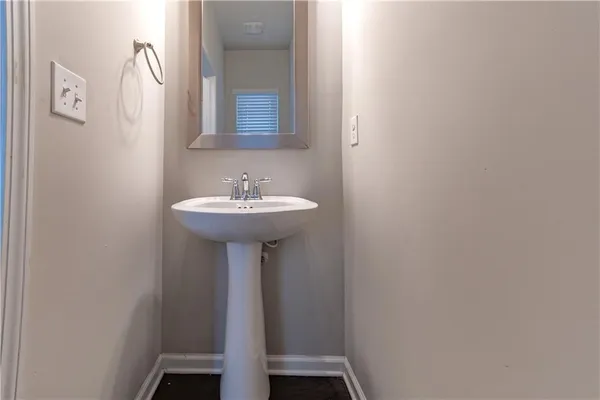 a bathroom with a sink a mirror and wooden floor