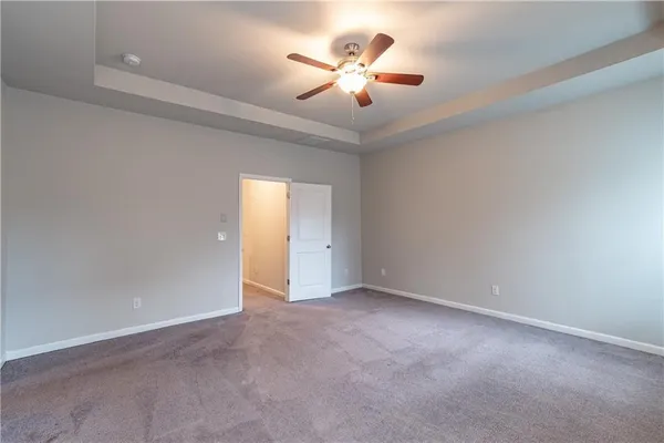 an empty room with a ceiling fan and a window