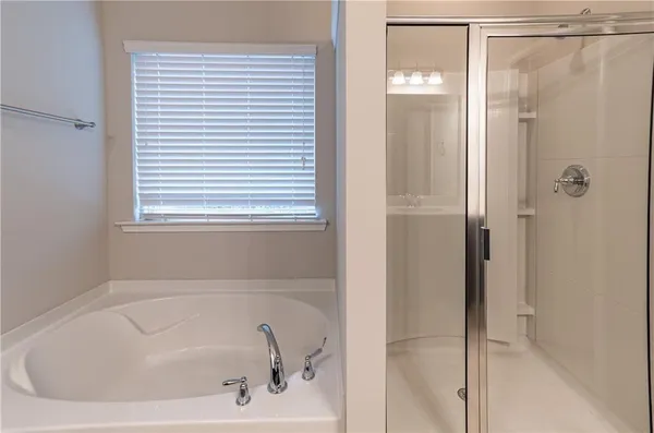 a white bath tub sitting next to a shower