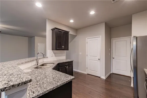 a kitchen with stainless steel appliances granite countertop a sink and a refrigerator