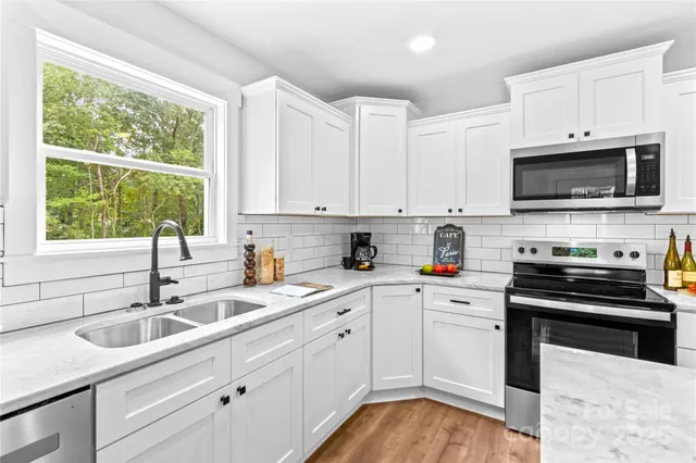 a kitchen with appliances a sink and cabinets