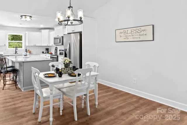 a view of a dining room with furniture wooden floor and chandelier