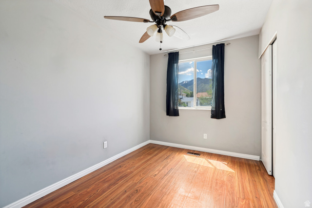 843 Deer Flat Road Tooele, UT 84074 - Photo 16 of 27 Room featuring wood-finish flooring, a ceiling fan with integrated lighting, and a window with mountain scenery