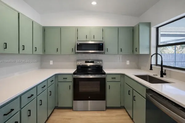 a kitchen with cabinets stainless steel appliances and a sink