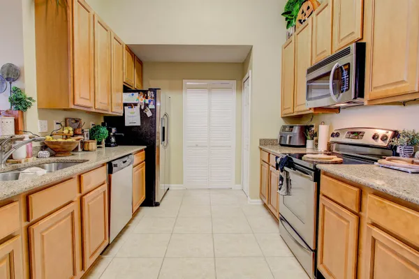 a kitchen with stainless steel appliances granite countertop a stove a sink and a microwave