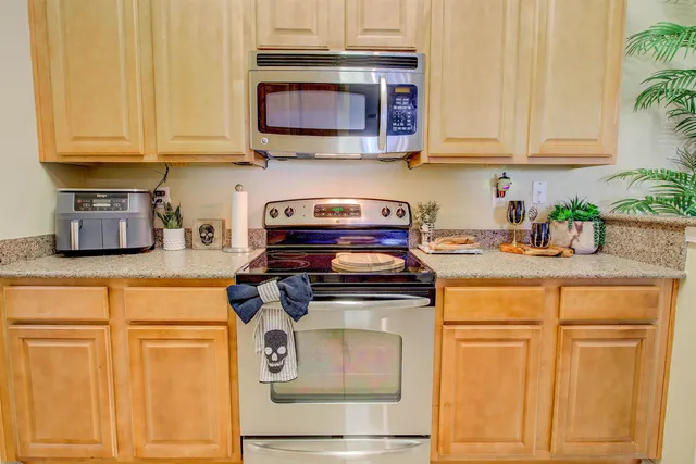 a kitchen with stainless steel appliances granite countertop a stove and a microwave