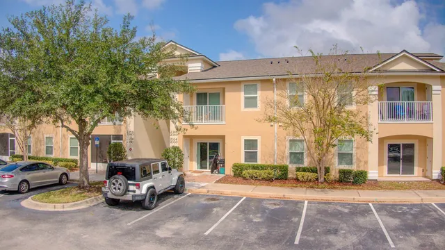 a view of a white house with a large windows and a small yard