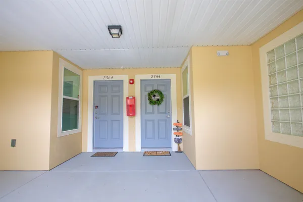 a view of an empty room with window and refrigerator