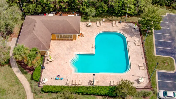 an aerial view of a house with a swimming pool and garden