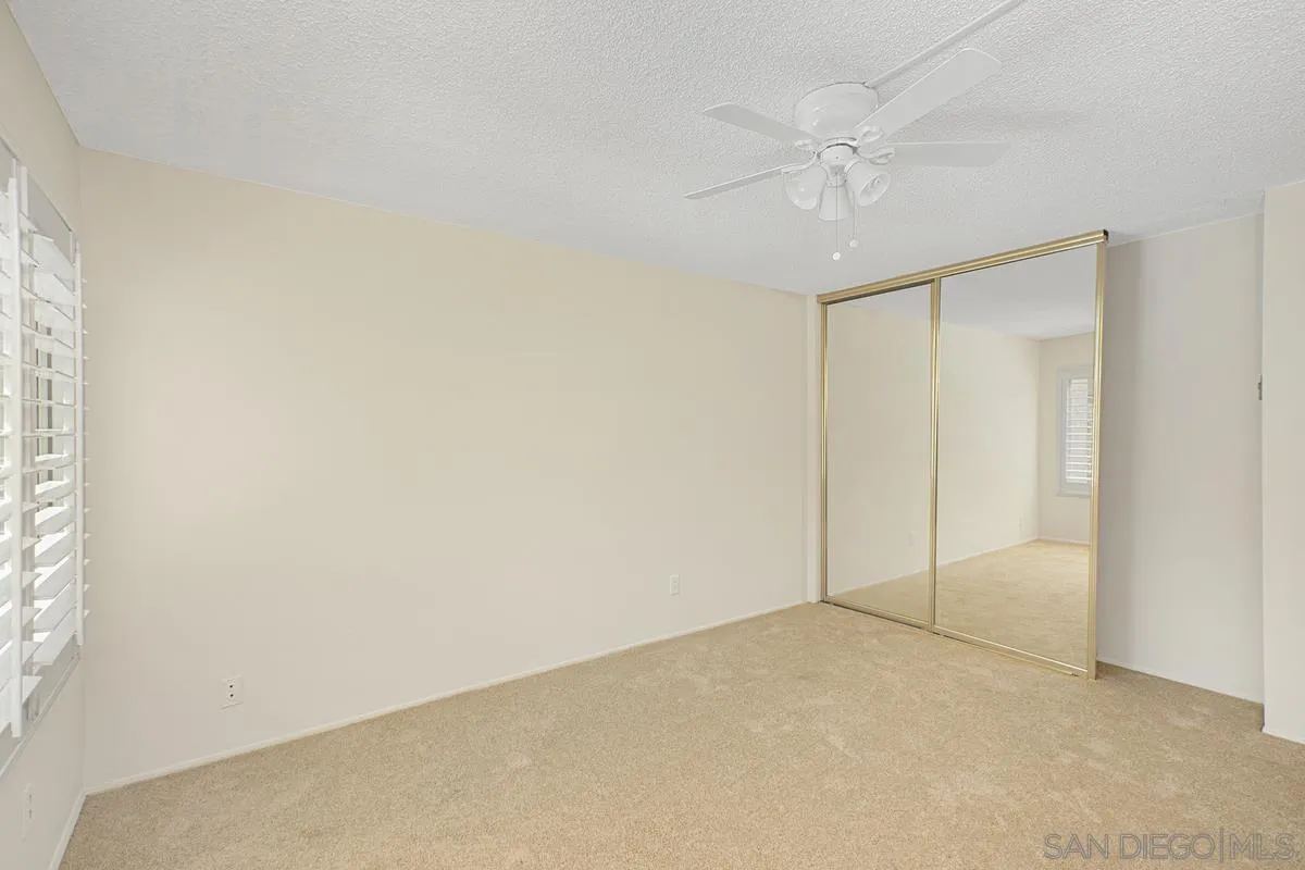 5906 Rancho Mission Road, Unit 5 San Diego, CA 92108 - Photo 15 of 33 an empty room with a ceiling fan and a window